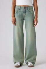 Pantalón de jean de tiro muy bajo con corte holgado y diseño de canesú en la cintura. Presenta un lavado desgastado en tono azul claro con costuras visibles.