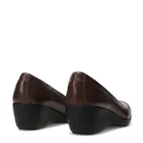 Zapato de cuero color marrón con taco cuña bajo y suela de goma negra. Presenta costuras decorativas en la parte frontal y un diseño de corte clásico.