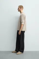 Sudadera de manga corta con corte relajado, confeccionada en tejido técnico compacto de algodón con elasticidad. Presenta cuello redondo y detalle de tacha metálica en la espalda.