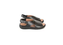 Sandalias de cuero negro con tiras cruzadas en el empeine, tira trasera ajustable con elástico y suela de poliuretano.