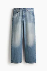 Pantalón de jean de corte holgado y pierna recta amplia, tiro caído y diseño de cinco bolsillos en denim de algodón rígido con efecto desgastado.