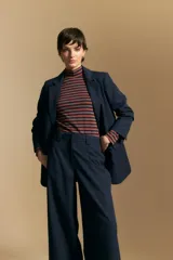 Pantalón de vestir negro de corte ancho y tiro alto, con silueta fluida y diseño minimalista.