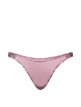 Tanga minimalista Victoria's Secret color rosa polvoriento, con tiro bajo, piernas de corte alto y tiras laterales brillantes con pedrería y logo de la marca.