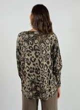 Blusa beige con estampado animal print de leopardo, escote en V y mangas largas.