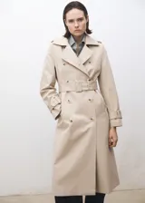 Trench coat de corte recto y diseño largo en color beige. Presenta cierre de doble botonadura, cuello con solapas de muesca, trabillas en los hombros y en los puños, y cinturón desmontable con hebilla a juego. Incluye dos bolsillos laterales y abertura posterior en el bajo.