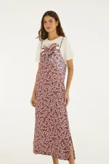 Vestido midi fluido de corte recto, con tirantes finos y diseño estampado floral en tonos bordó y lila.