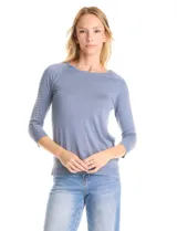 Buzo de tejido fino en color blanco, con cuello redondo y mangas raglán tres cuartos. Presenta una línea de tachas decorativas a lo largo de las mangas.