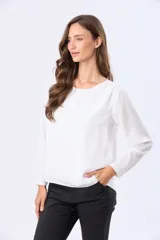 Blusa clásica de manga larga en color blanco, con cuello redondo y diseño fluido.