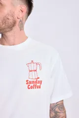 Remera blanca de manga corta con corte oversize y estampa en la espalda con la frase "Chill Sunday Coffee Club" y una cafetera italiana.