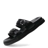 Sandalias planas color negro con dos tiras anchas en el empeine, cada una con hebilla metálica plateada ajustable. Poseen suela con ligera plataforma y diseño texturizado en el borde.