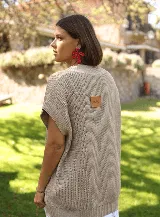 Chaleco de punto color beige, con escote en V y diseño holgado sin mangas.