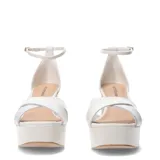 Sandalias de mujer marca Bottero, color blanco, con diseño de tiras cruzadas en el empeine, plataforma delantera y tacón ancho. Incluyen pulsera ajustable al tobillo con cierre de hebilla.