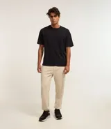 Pantalón jogger color beige confeccionado en algodón y poliéster. Cuenta con cintura elástica ajustable con cordón, bolsillos laterales y puños elásticos en los tobillos.