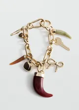 Llavero dorado con cadena de eslabones y múltiples dijes colgantes, incluyendo cuernos de resina en tonos bordó, marrón y verde, un moño marinero, una llave y un dije cuadrado.