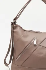 Cartera convertible en mochila, confeccionada en cuero sintético texturizado color marrón. Presenta un diseño con recortes, bolsillo frontal con cierre diagonal, herrajes metálicos plateados, asa superior y correas regulables.