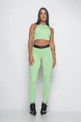 Calza deportiva color verde claro, de tiro alto y corte ajustado. Presenta cintura elástica con logo en relieve.