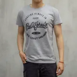 Remera gris de algodón con estampa negra que dice 'Surfing always in Duxon California West Coast Dreamin - Est. 1982'.