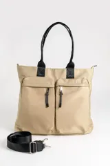 Bolso grande de color beige con dos bolsillos frontales con cierre, manijas superiores negras y correa ajustable extraíble.
