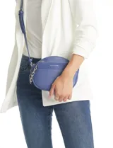 Cartera tipo bandolera de eco cuero con silueta de media luna, color beige y detalles en marrón claro. Incluye un monedero/tarjetero independiente en el bolsillo frontal y una cadena decorativa de eslabones dorados.
