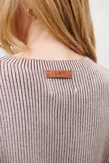 Buzo de tejido de punto acanalado en color beige, con cuello redondo, mangas largas y un bolsillo frontal aplicado en la parte inferior.