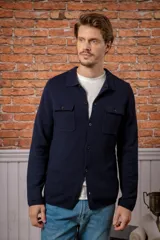 Overshirt de lana melange en color gris, con cuello camisero, cierre frontal de botones y dos bolsillos frontales con solapa.