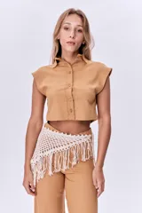 Camisa corta color ocre de lino, con cuello clásico, cierre frontal con botones y mangas cortas con solapas.