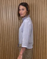 Camisa de algodón color blanco, con cuello alto con volados, mangas tres cuartos con detalles de bordado ingles y cierre frontal con botones de nácar.
