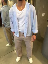 Camisa de corte relajado, color celeste pastel, con cuello cubano y mangas largas arremangadas.