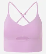 Top deportivo color rosado claro, con breteles finos ajustables que forman una X en la espalda. Presenta una banda ancha bajo el busto y un detalle de corte (cutout) en la parte delantera del busto.