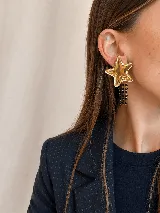 Aros de acrílico espejado con resina en forma de estrella dorada, con tres tiras de cadena colgantes decoradas con mostacillas negras.