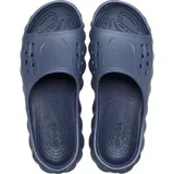 Chancla Crocs Echo Slide, completamente moldeada en color negro, con diseño esculpido y audaz, orificios de ventilación en la parte superior y suela con relieve ondulado.