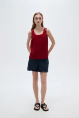 Musculosa de viscosa color beige claro, holgada, con cuello redondo y tirantes anchos formados por múltiples tiritas trenzadas.