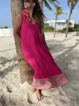Vestido largo de fibrana fucsia con volado rosa en el ruedo y tiras finas que se atan en los hombros.