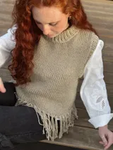 Chaleco tejido a mano color beige con cuello alto y flecos en el ruedo. Hecho por encargo en lana.