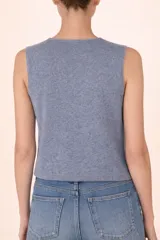 Chaleco de punto color gris, sin mangas, con cuello redondo y cierre frontal mediante botones decorativos tipo perla.