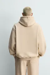 Sudadera con capucha de corte relajado, confeccionada en tejido de algodón con interior perchado. Presenta mangas largas, bolsillo frontal tipo canguro y terminaciones en rib.