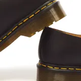 Zapatos Mary Jane Dr. Martens modelo 8065 Black Smooth, fabricados en cuero negro con doble tira ajustable mediante hebillas metálicas doradas, puntera con perforaciones decorativas tipo brogue y suela acolchada con costuras amarillas.