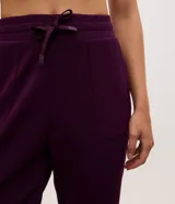 Pantalón tipo jogger de mujer, confeccionado en tejido modal con mezcla de poliéster y elastano. Presenta cintura elástica con lazo de ajuste, bolsillos laterales y puños elásticos en el ruedo.