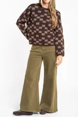 Sweater de punto con diseño de cuadros en tonos marrón y beige, de corte recto, cuello redondo y manga larga.