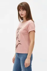 Remera de algodón blanca de manga corta y cuello redondo, con estampa frontal que combina franjas verticales verdes y un diseño ovalado con fresas rojas.