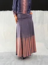 Falda larga de algodón color lavanda con teñido degradado en tonos rosados. Corte a la cintura con dos bolsillos laterales y cierre invisible.