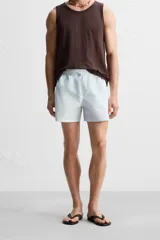 Short de baño celeste con estampado geométrico paisley, cintura elástica con cordón ajustable, bolsillos laterales y bolsillo trasero.