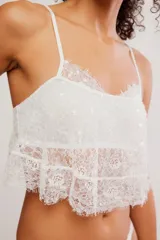 Top brami blanco de encaje translúcido, con tiras finas regulables, escote recto y dos volados superpuestos con terminación en festón.