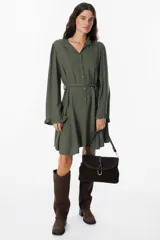 Cartera de hombro confeccionada en cuero gamuzado color chocolate, con solapa frontal y cierre mediante una tira de cuero con herraje metálico en forma de herradura.