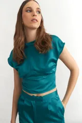 Top corto de seda color verde esmeralda, con cuello mao y mangas cortas.
