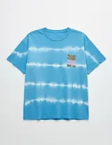 Remera de manga corta con efecto batik horizontal en tonos azules y blancos, de calce holgado y cuello redondo. Presenta un pequeño estampado gráfico en el pecho.