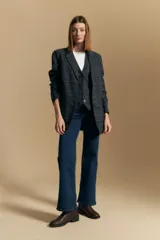 Blazer de corte sastrero con estampado de cuadros en tonos beige, marrones y rojizos. Presenta solapas clásicas, cierre frontal con un botón y bolsillos laterales con solapa.