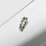 Anillo plateado con cristales multicolores rectangulares.