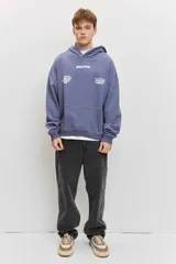 Canguro de friza color azul acero, con capucha, bolsillo tipo canguro y estampado gráfico en el pecho con texto en blanco.