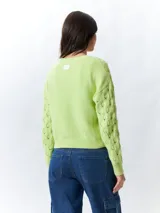 Sweater color crema tramado de manga larga y cuello redondo.